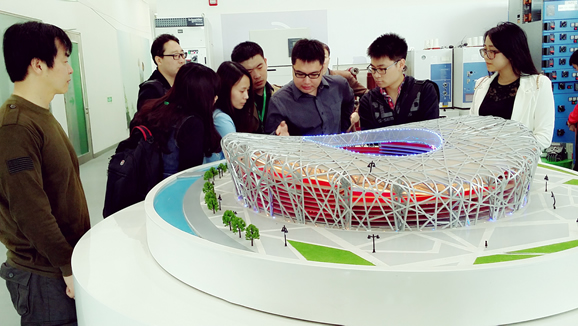 图中讲解工程师正在为媒体介绍施耐德电气在北京奥运会建设中实现配电、照明等